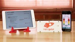 Astropint interface on a table displays an iPad with a file management screen, an Astroprint box with a rocket logo, and a smartphone with a printer temperature interface.
